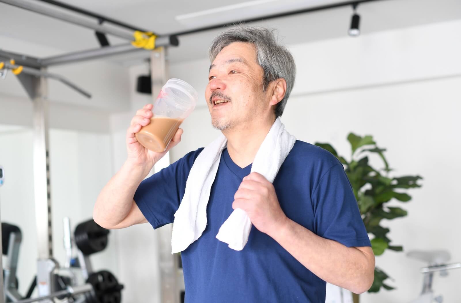 A senior drinks from a mix of water and protein powder to support their health after working out