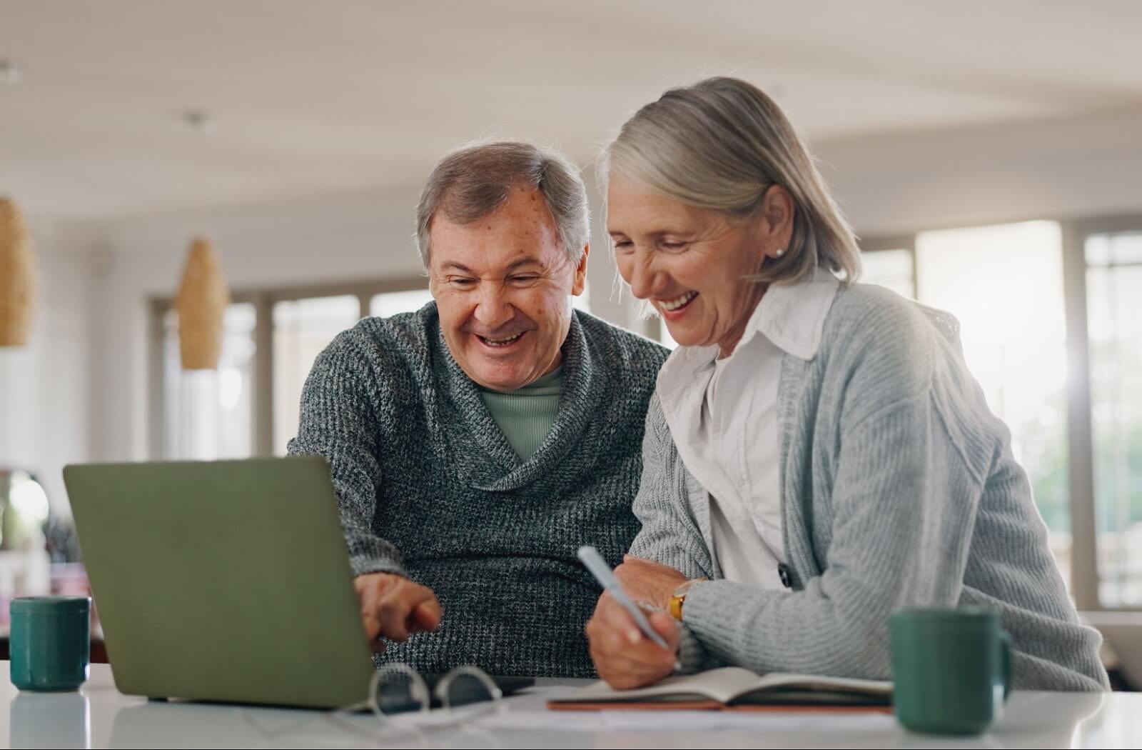 A group of seniors cheers their cups of coffee and orange juice together over a community brunch in assisted living