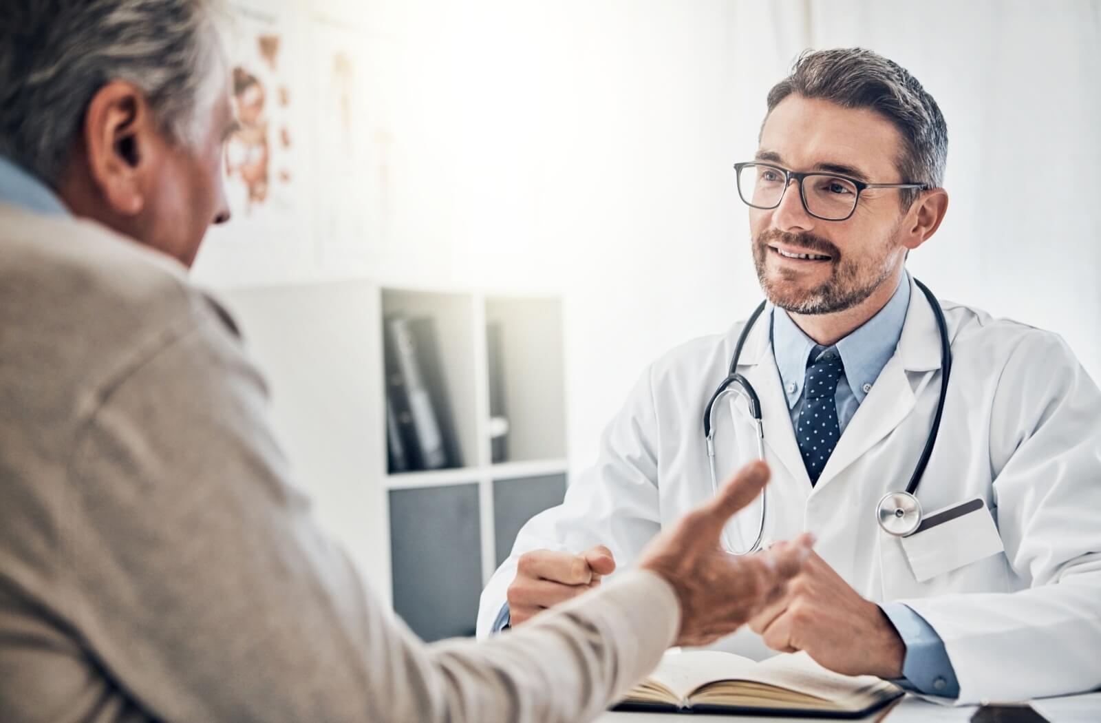 An older adult sits in a doctor's office during a checkup after trying the FAST scale to learn about their recent memory issues